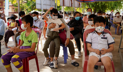 Children and their parents wait to receive a vaccine against the coronavirus disease